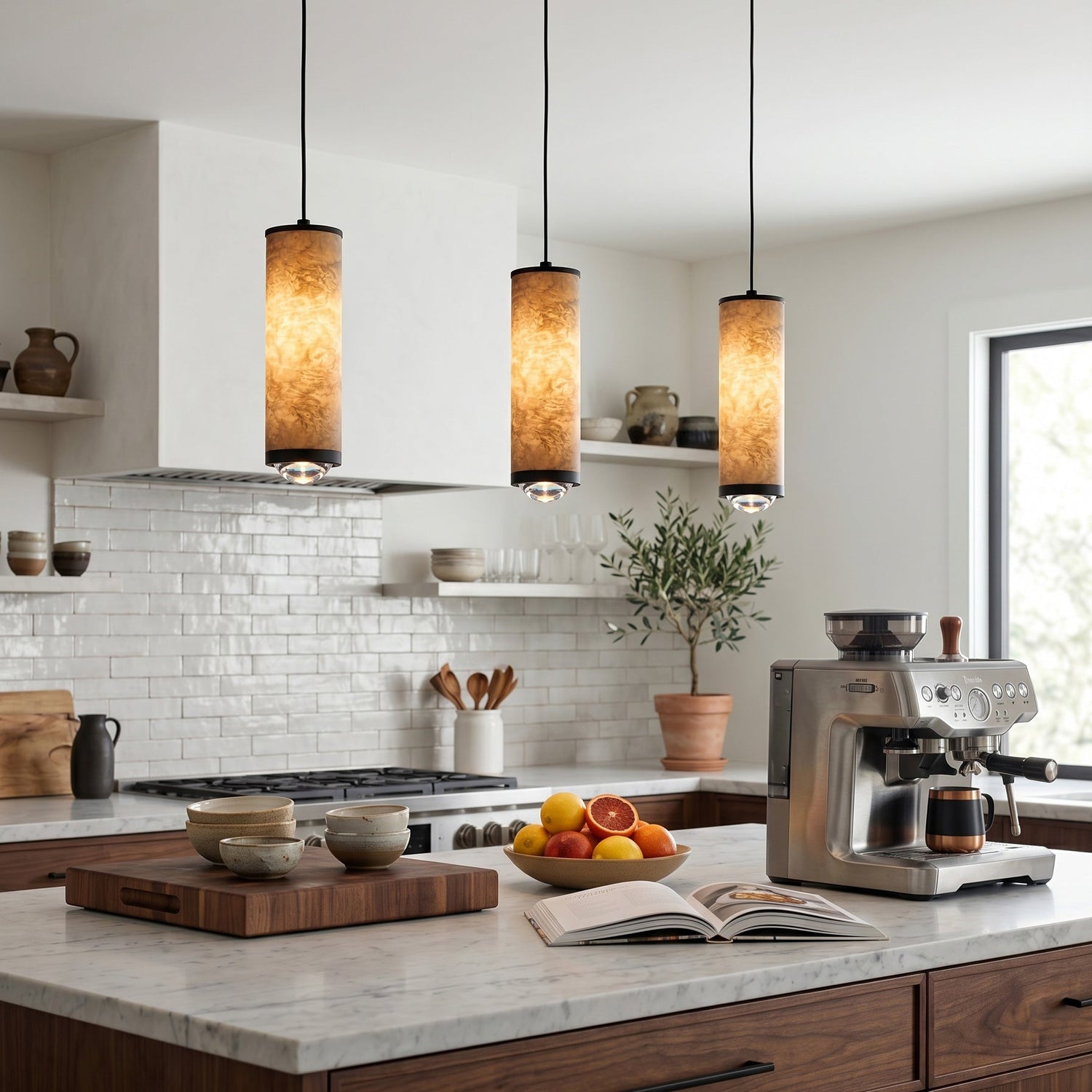 Cylindrical alabaster pendants over a kitchen island